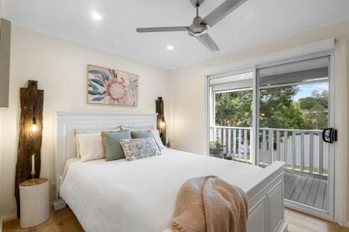 a bedroom with a white bed and a balcony at Kyogle Farmstay - Charming Country Cottage in Homeleigh