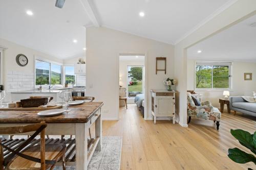 a kitchen and living room with a table and a dining room at Kyogle Farmstay - Charming Country Cottage in Homeleigh