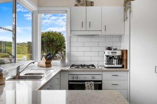 a kitchen with white appliances and a large window at Kyogle Farmstay - Charming Country Cottage in Homeleigh