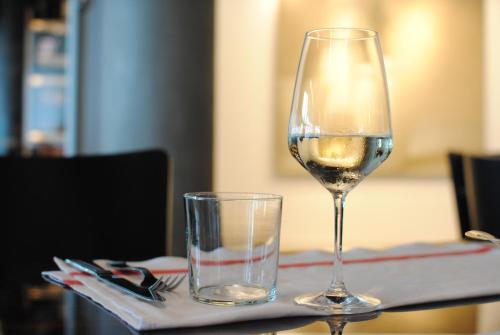 a glass of white wine and a glass of water on a table at Savoia Hotel Rimini in Rimini