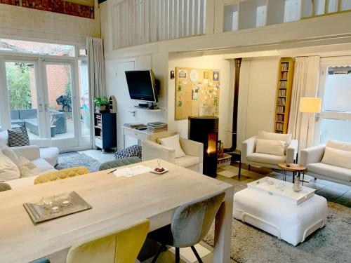 a large living room with a table and chairs at Gezellig Cottage Markdal met gratis fietsen in Breda
