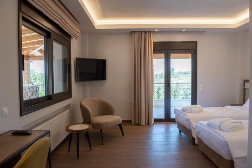 a hotel room with two beds and a television at Serenity Residence in Neoi Epivates