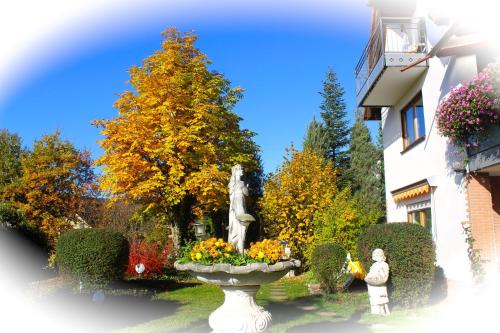 a statue in a garden in front of a building at Pension Höchemer in Bad Bocklet