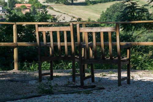 a wooden bench sitting next to a fence at il sogno di Tino in Cabernardi