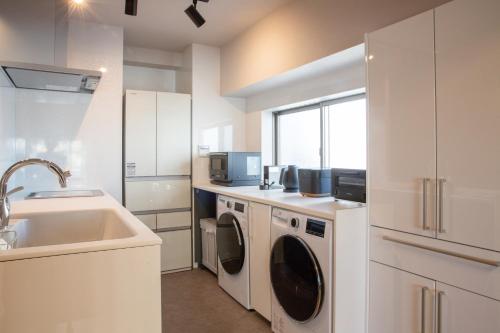 a kitchen with a washing machine and a sink at NIYS apartments 82type in Tokyo