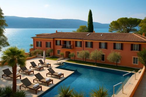 a house with a swimming pool next to the ocean at Boutique Hotel Bogliaco in Gargnano