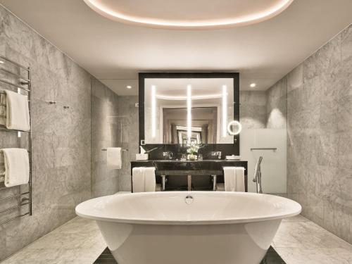 a bathroom with a large tub and a sink at Hyatt Regency Amsterdam in Amsterdam