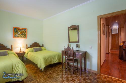 a bedroom with two beds and a desk and a mirror at Duas Aguas Arribes in Bemposta