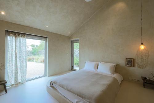 a bedroom with a large bed and a large window at 스테이스스와 야외자쿠지무료 in Sogil-li