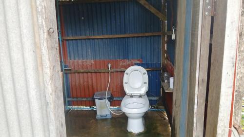 a bathroom with a toilet in a garage at Eco Lotus Kampot in Kampot
