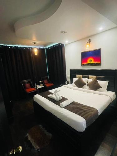 a hotel room with a large bed with white sheets at Upper city heart hotel #Atithi Devo Bhava #Mountain View # Cheap Hotel Best Prices Guaranteed with Deals#Free Parking#cricket stadium 8 km#Mcleodganj 2 km- Bhagsunag 4 km in Dharamshala