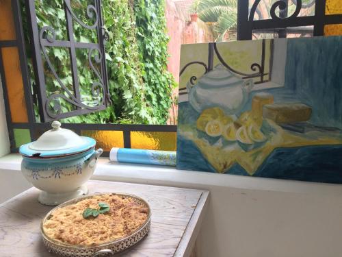 un tavolo con una ciotola di cibo e un dipinto di Casa Viva Hotel Boutique a Junín