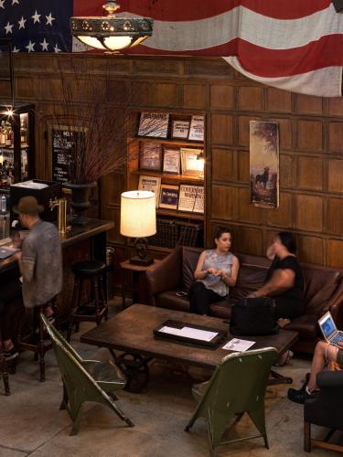 a group of people sitting on couches in a bar at Ace Hotel New York in New York