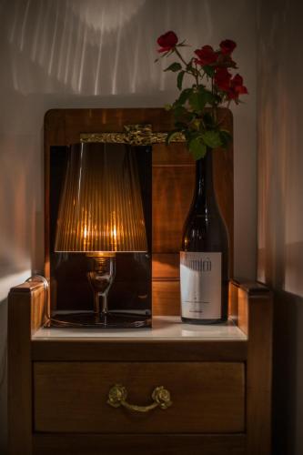 a bottle of wine and a vase with a flower at Palazzo Tronconi agriturismo in Arce