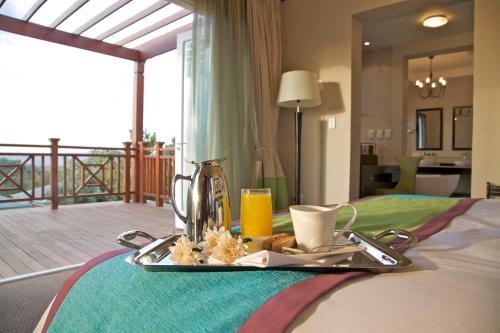 a tray with a breakfast on top of a bed at Mount Grace Hotel & Spa in Magaliesburg