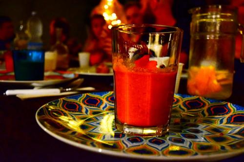a glass of red liquid sitting on a plate at Timbuktu Hostel in San Vito lo Capo