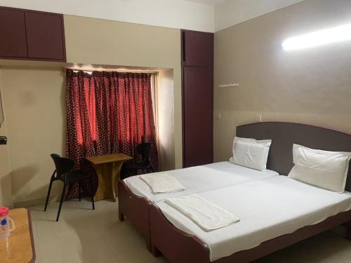 a small bedroom with a bed and a window at Hotel Vimas International in Madurai