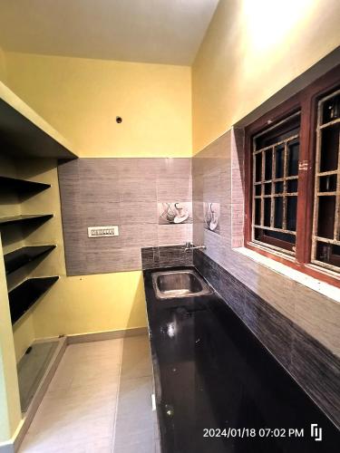 a kitchen with a sink in the corner of a room at BNS Village Resort in Kolli Hills
