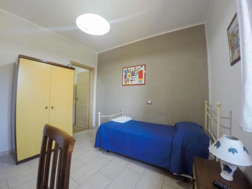 a bedroom with a bed with a blue comforter at Salisù Country House in Mignano Monte Lungo
