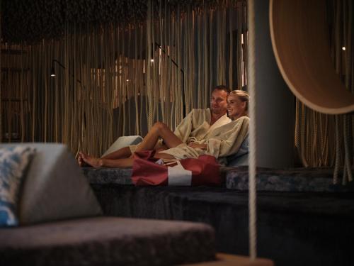 a man and a woman sitting on a couch at Hotel Salzburger Hof Leogang in Leogang