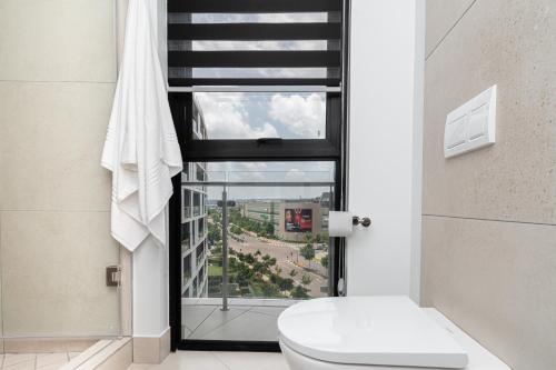 a bathroom with a toilet and a window at Elegant AirConditioned Neria at Ellipse Waterfall in Midrand