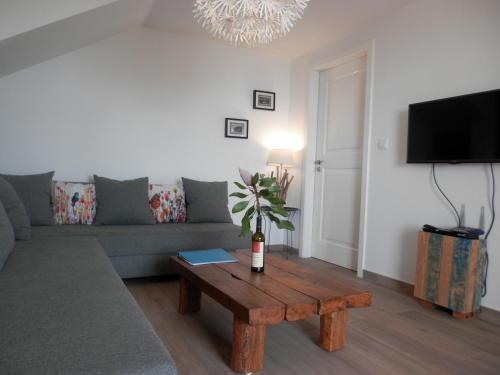 a living room with a couch and a wooden coffee table at Au petit Madère in Prazeres