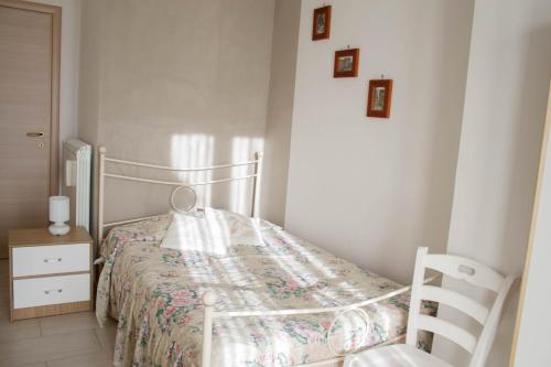 a small bedroom with a bed and a chair at Salisù Country House in Mignano Monte Lungo