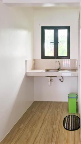 a white bathroom with a sink and a window at Coconut El Nido in El Nido