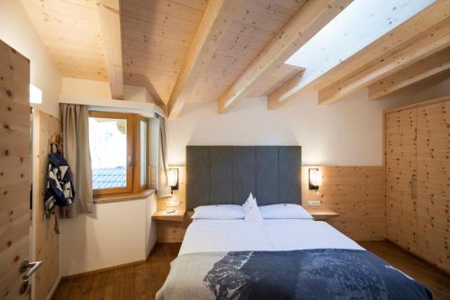 a bedroom with a large bed and a window at Familienhotel Huber in Valles