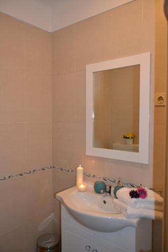 a bathroom with a sink with a candle and a mirror at Casinha das Flores in Reguengos de Monsaraz