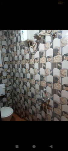 a bathroom with a shower curtain and a toilet at Blue Sapphire in Hinjewadi
