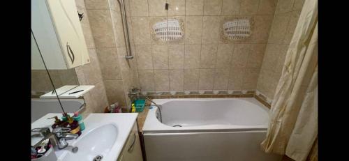 a bathroom with a bath tub and a sink at Ciocana in Chişinău