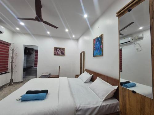 a bedroom with a large white bed with blue pillows at EVA AYURVEDIC beach hotel in Varkala