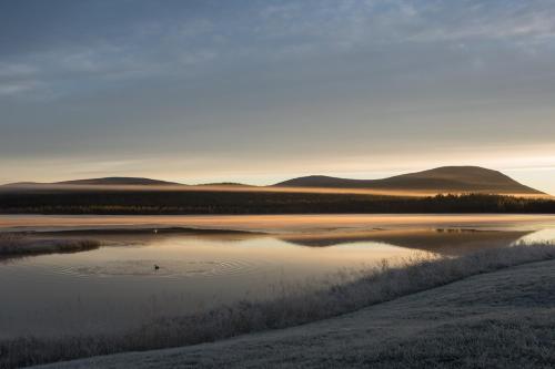 a view of a lake with mountains in the background at Ylläksen Yöpuu in Äkäslompolo