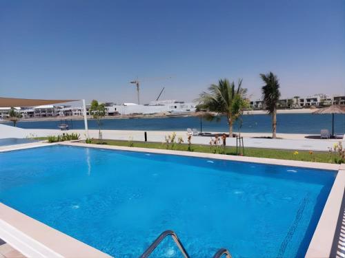 a large blue swimming pool in a resort at Livin' Holidays - 3BR - Family Friendly Townhouse w Private Pool in Ras al Khaimah