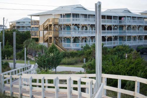 a white fence in front of a building at Atlantic Beach Resort, a Ramada by Wyndham in Atlantic Beach