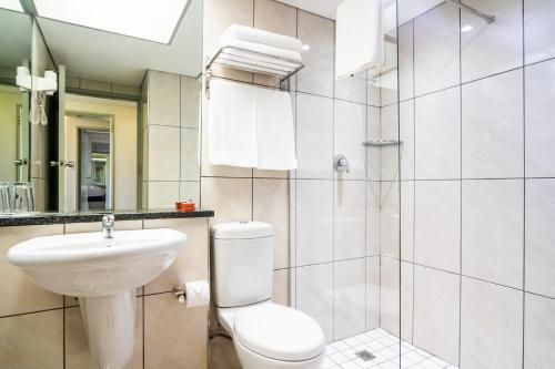 a bathroom with a toilet and a sink and a shower at African Sky Harrismith Inn in Harrismith