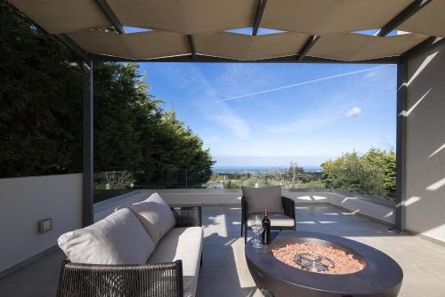 a patio with a couch and a coffee table on a balcony at Vilana Exclusive Villas in Skouloúfia