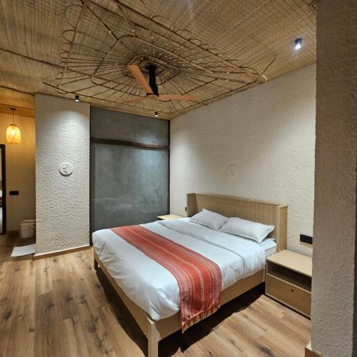 a bedroom with a large bed and a ceiling with aumedumedumedumedumed at Aaryavan, A boutique resort in Mount Ābu