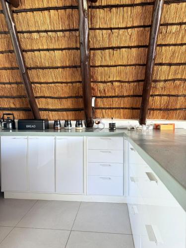 a kitchen with white cabinets and a wall at Picturesque 82 in Buffelspoort