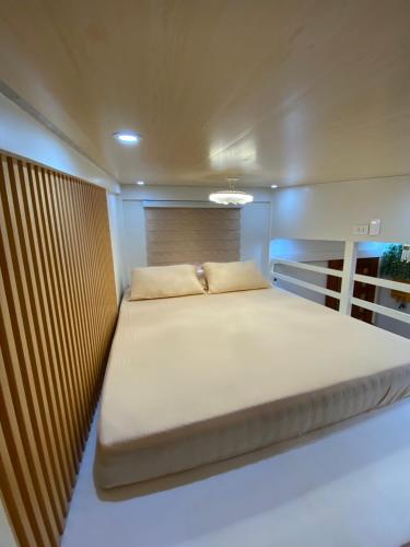 a large bed in a small room on a boat at Urban Haven- Naga City in Naga