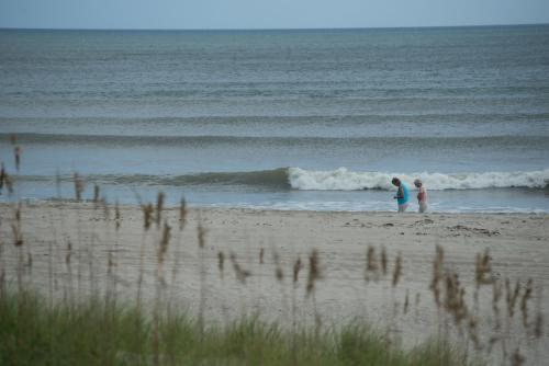 two people standing in the water on a beach at Atlantic Beach Resort, a Ramada by Wyndham in Atlantic Beach