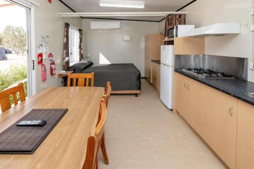 a kitchen and dining room with a table and a bed at BIG4 Opal Holiday Park in Lightning Ridge