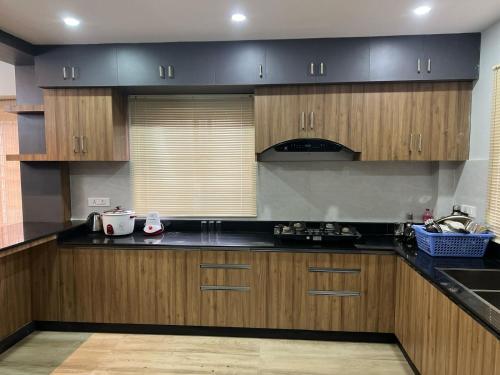 eine Küche mit schwarzen Arbeitsplatten und Holzschränken in der Unterkunft Sabhya Prestige in Pokhara