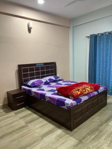 Sabhya Prestige في بوخارا: غرفة نوم بها سرير باللون الأرجواني وأرجواني