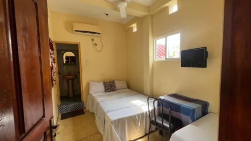 a small bedroom with a bed and a window at Manimalar guest in Colombo