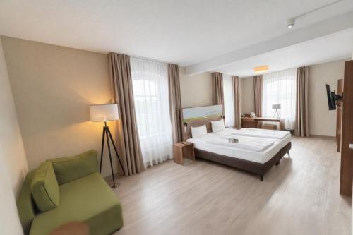 ein Hotelzimmer mit einem Bett und einem Stuhl in der Unterkunft Hotel Dampfmühle in Neukirchen-Vluyn