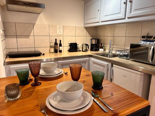 a kitchen with a wooden table with plates and bowls at Domaine de la Mance - Maisonnette avec cheminée, bain nordique en supplément in Vitrey