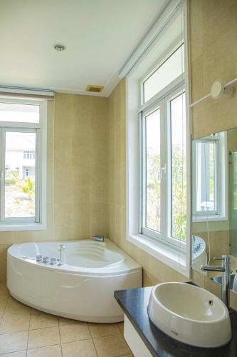 a large bathroom with a large tub and a sink at Căn Hộ OceanVista & Biệt Thự Sealink Phan Thiết - Mũi Né in Phan Thiet