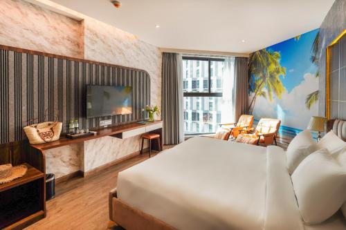 a hotel room with a bed and a television at Apec Mandala Chambay Mui Ne - Oceanic Studio in Mui Ne